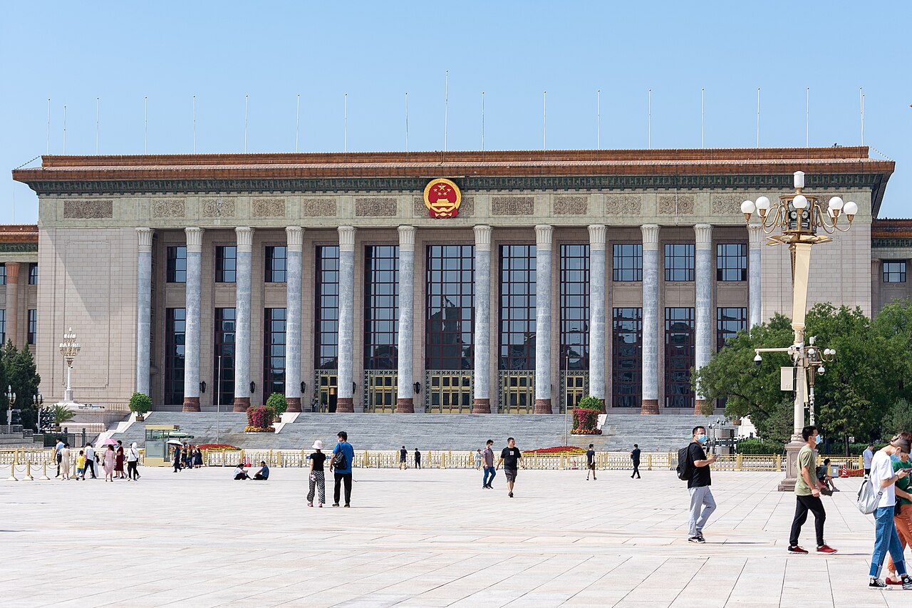 The colonnaded facade of Beijing’s Great Hall of the People, with visitors crossing Tiananmen Square.
